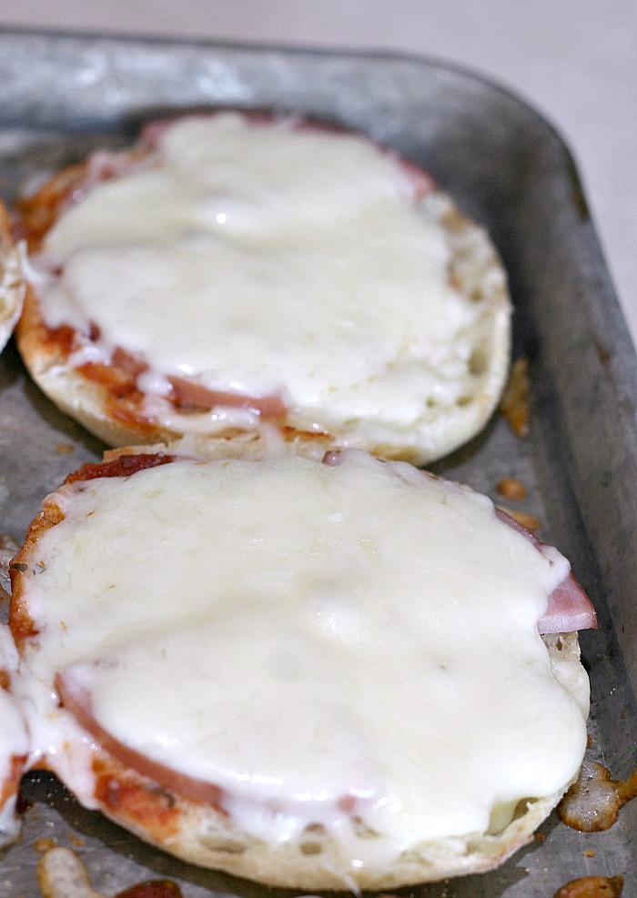 cooked english muffin pizzas on a cookie sheet