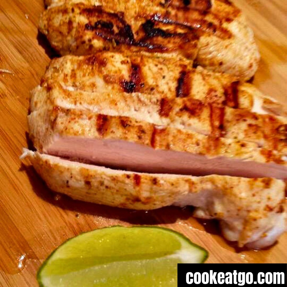 Sliced Lime Chicken  on a cutting board with a lime wedge next to it 