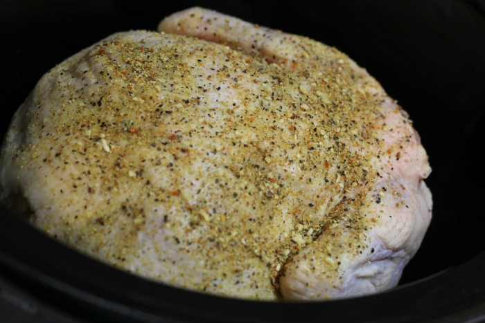 Lemon pepper whole chicken in crockpot before cooking 
