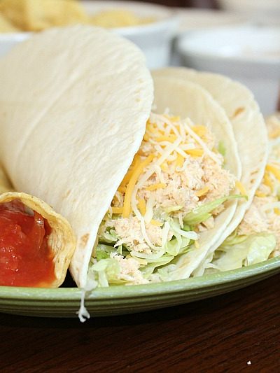 These2 Ingredient Crock Pot Chicken Tacos are the perfect dinner for a crazy school night. My kids loved these and they were super easy to make.