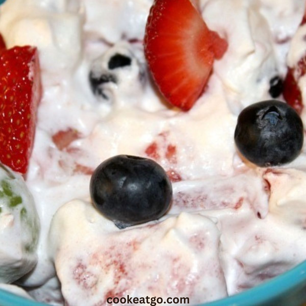 Strawberries blueberries, grapes, and watermelon in whipped topping