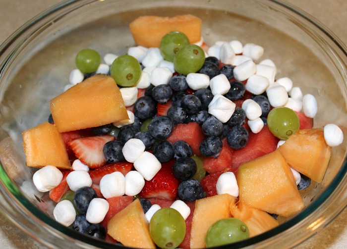 Cantaloupe, blueberries, strawbereies, watermelon, and grapes in a mixing bowl