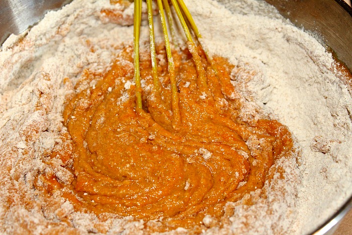 Cake Mix Being Mixed Into Pumpkin Puree For Muffins With A Silicone Whisk 