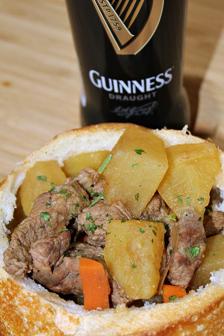 Slow Cooker Guinness Beef Stew  served in bread bowl with a guinness beer