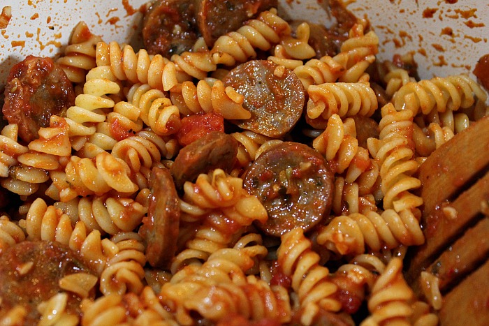 Cooked rotini pasta with sausage and sauce in pan