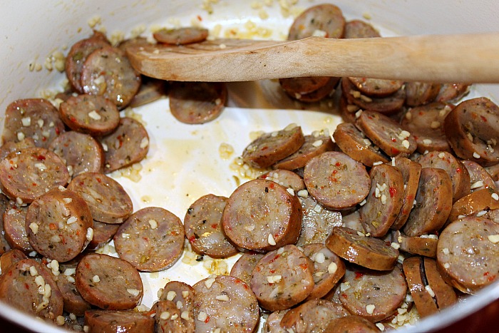 Sausage Being cooked in pan with minced garli
