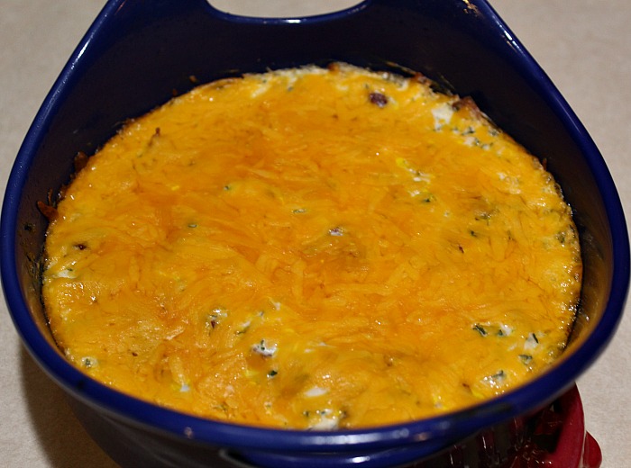 This Creamy Cheddar Bacon Dip baked in a blue rachel ray dish 