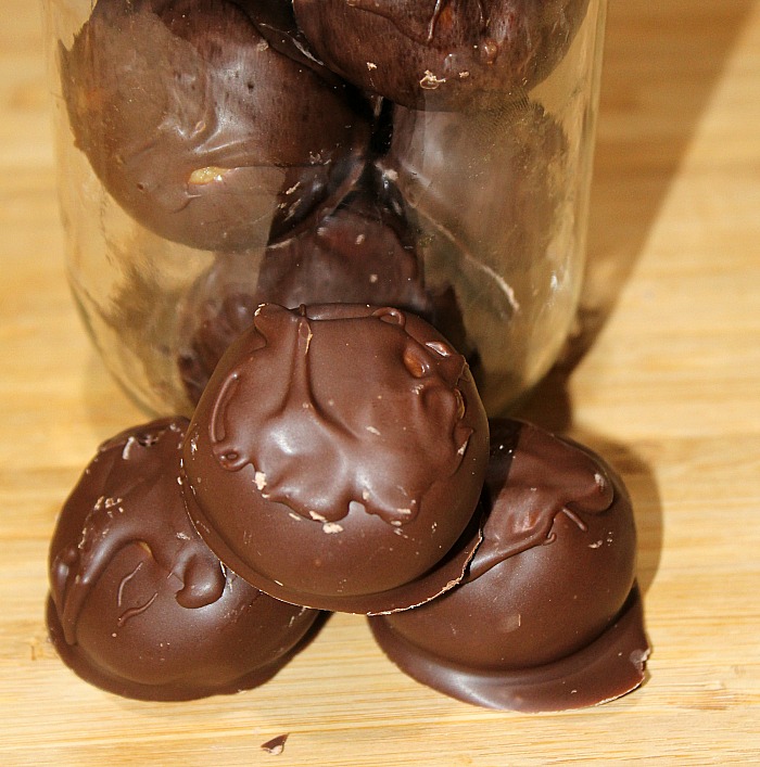 Chocolate Peanut Butter Balls stacked in mason jar and on cutting board