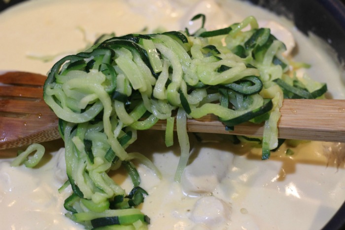 Zoodles going into cooked chicken with alfredo sauce