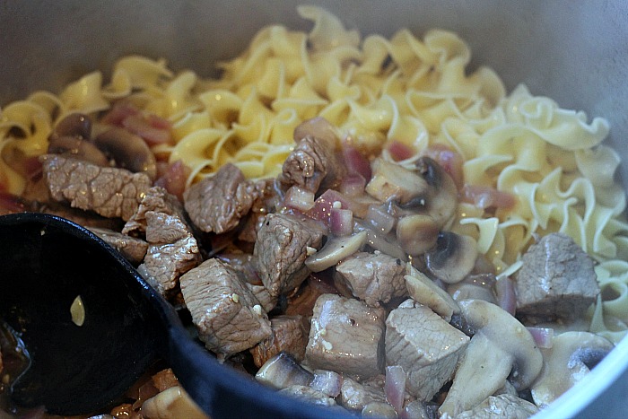 Beef Stroganoff being mixed into egg noodles 