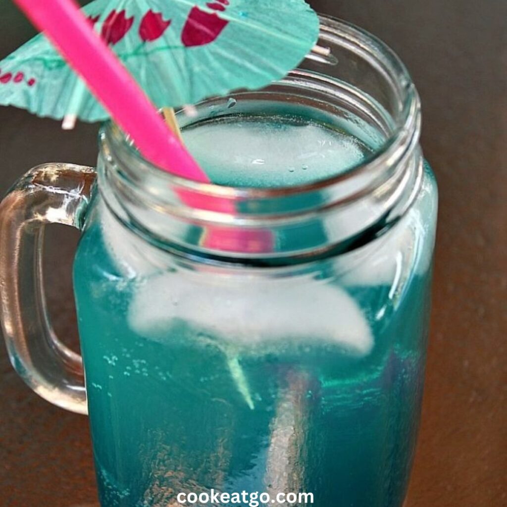 Mermaid Water cocktail served in mason jar with umbrella