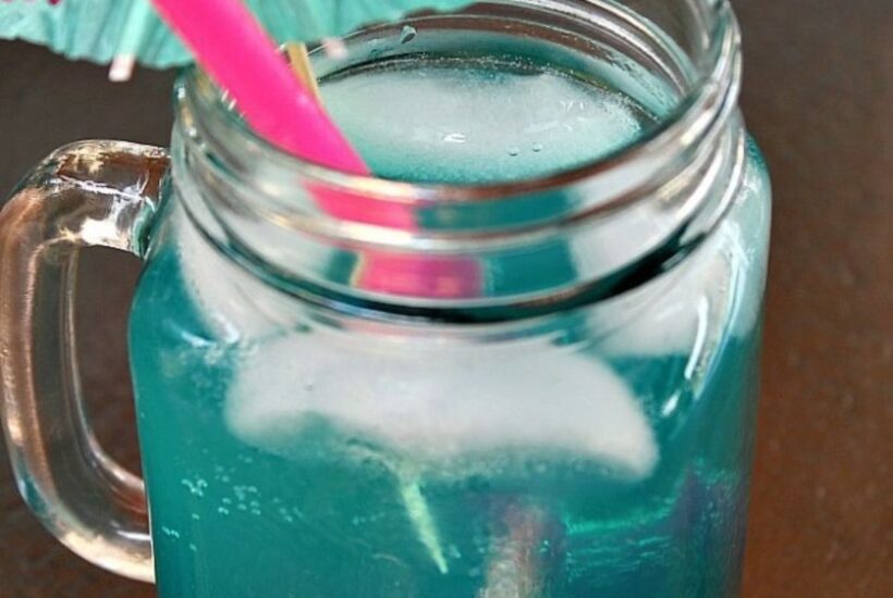 Mermaid Water cocktail served in mason jar with umbrella