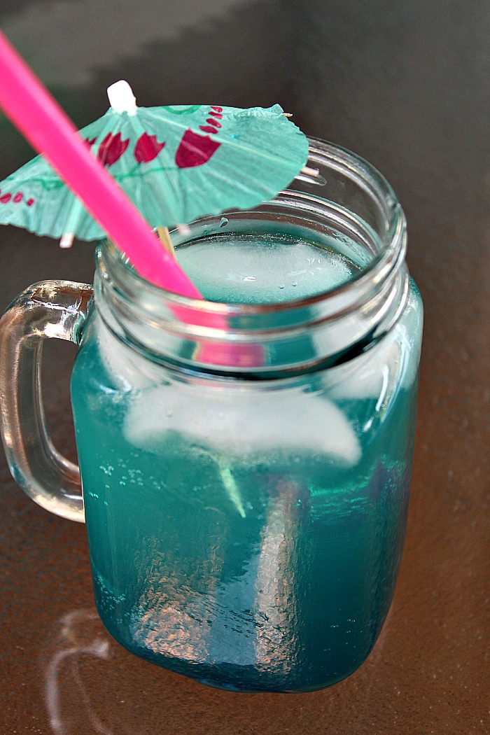 This Mermaid Water Cocktail is full of flavor and an easy cocktail to make at home to take yourself to a tropical getaway at home as well! Make a pitcher to take to a get-together or a night in the girls!