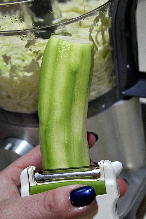 Peeled Zucchini with food processor full behind it 