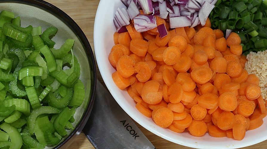 Chopped Vegetables in bowls with knife on a cutting board. 