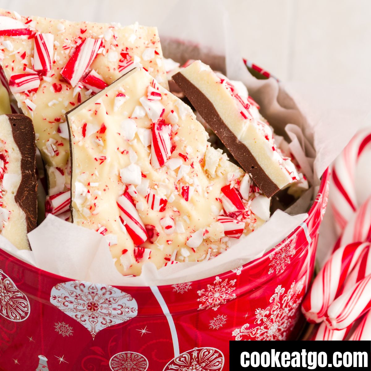 Peppermint bark in a container with candy canes next to it 