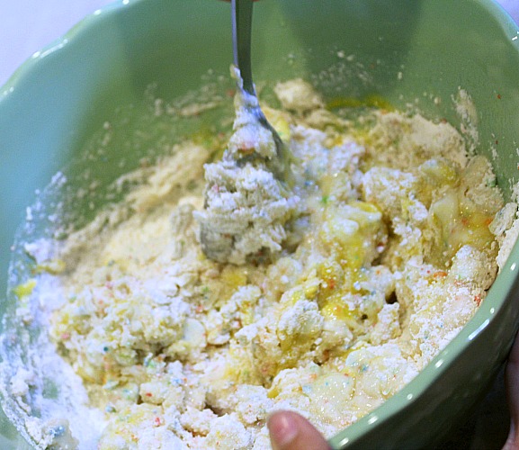 Rainbow Chip Cake Mix Cookies being mixed in bowl with large spoon