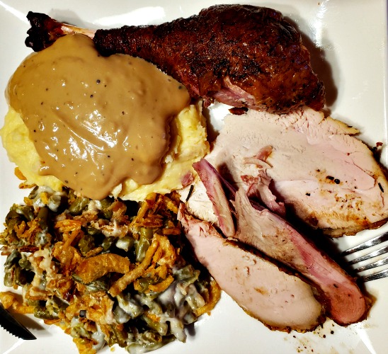 Smoked Turkey Leg With Mashed Potatoes, Ham, and green bean casserole on plate 