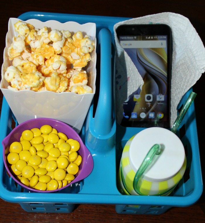 Blue caddy with popcorn and cup with phone 