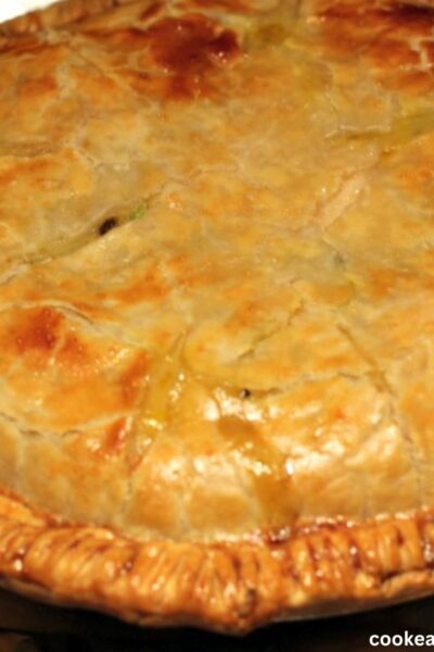 Homemade chicken pot pie recipe baked in a pie tin on a cookie sheet