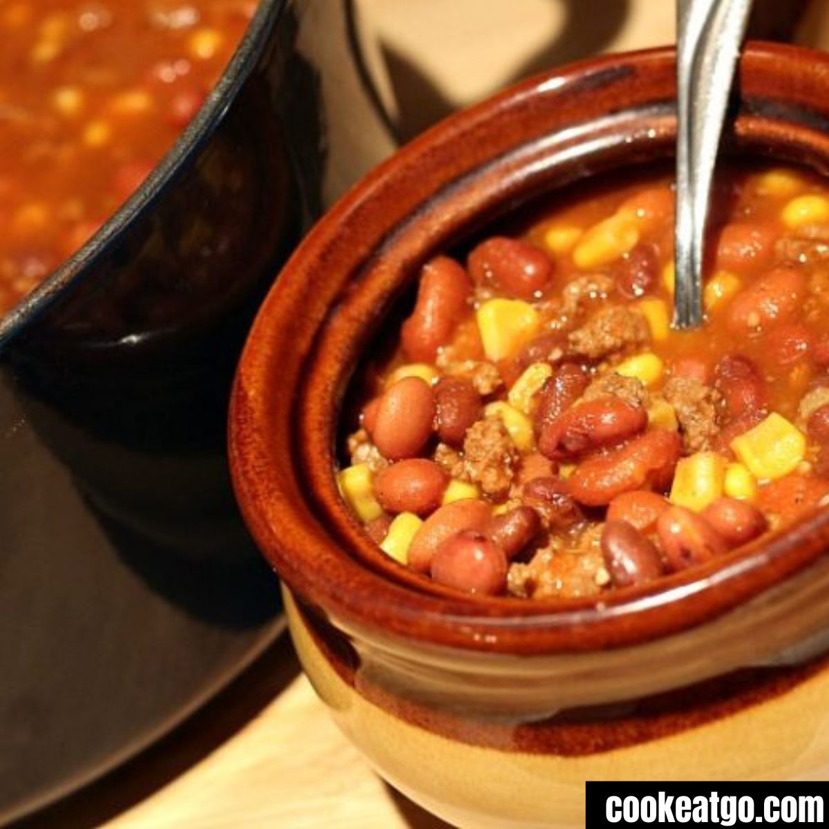 Dutch Oven with beef chili next to a soup crock served with beef chili