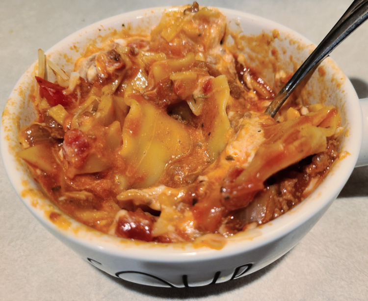 Cooked Lasagna Soup in bowl topped with cheeses and stirred after cheese melts!  