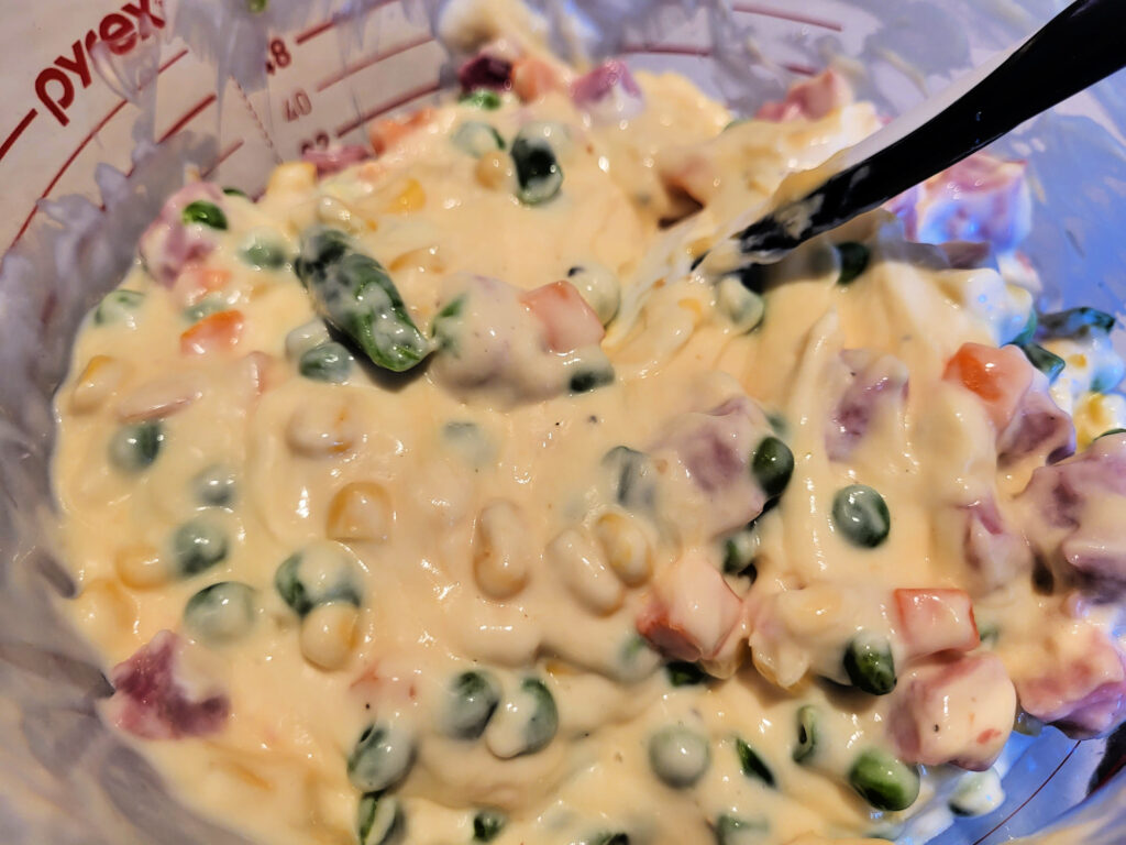 Cheesy Ham Noodle Casserole Peas With Ham and Sauce In Bowl Mixed