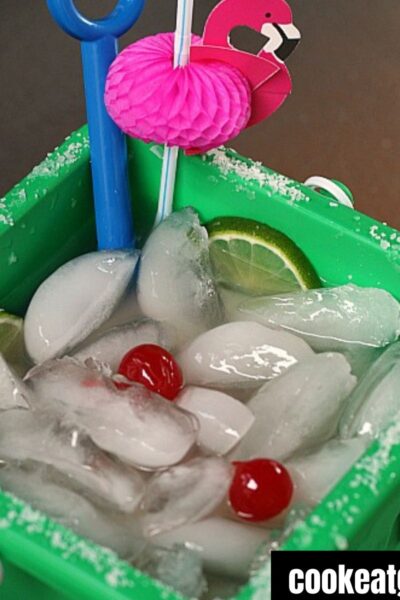 Margarita bucket drink served with a straw and flamingo decorations