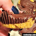 Homemade peanut butter cups with a bite out of it with moer behind it