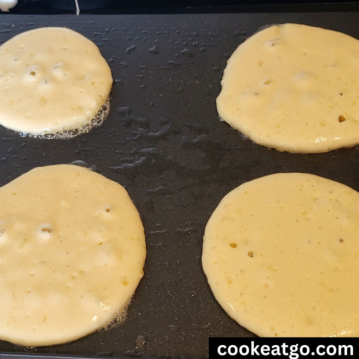 Homemade pancakes cooking on an electric griddle