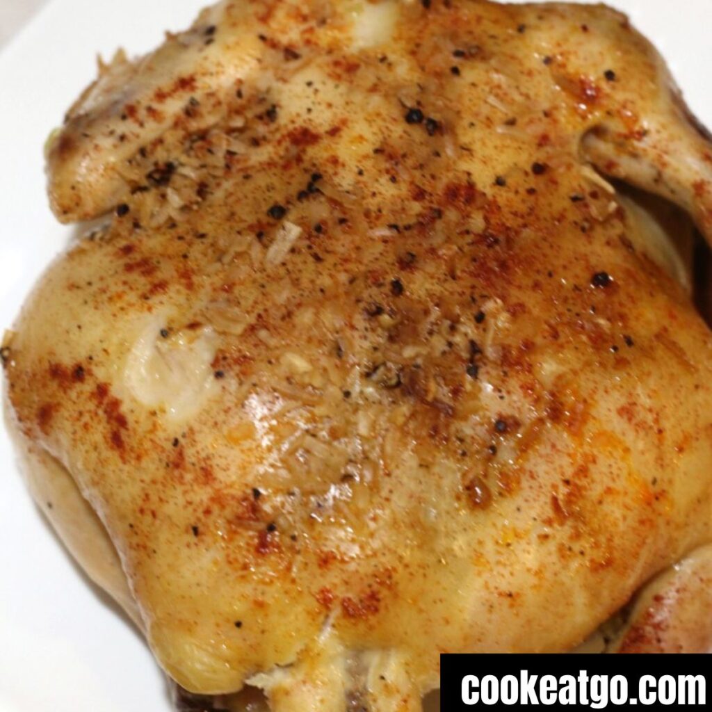 Cooked whole chicken in a crockpot on a white platter