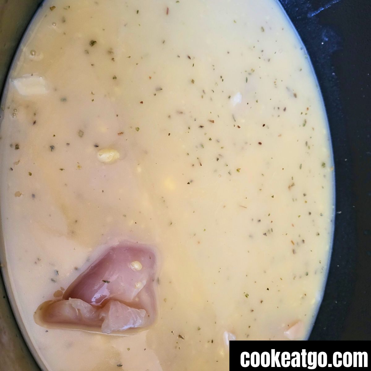 Raw chicken breasts in broth for chicken and dumpling