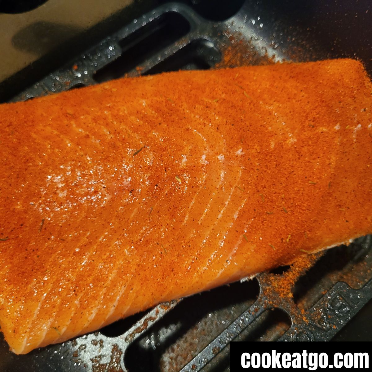 Salmon Fillet seasoned with trader joes rub in air fryer basket before cooking