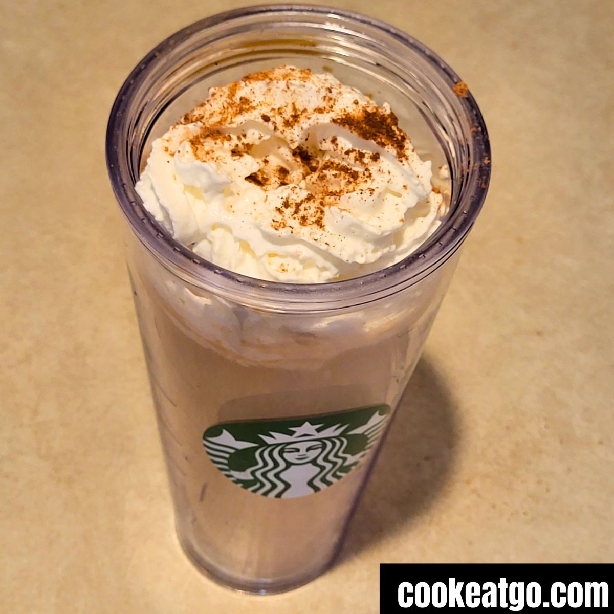Skinny Pumpkin Spice latte topped with whipped topping sprinked with pumpkin spice seasoning in venti starbucks cup