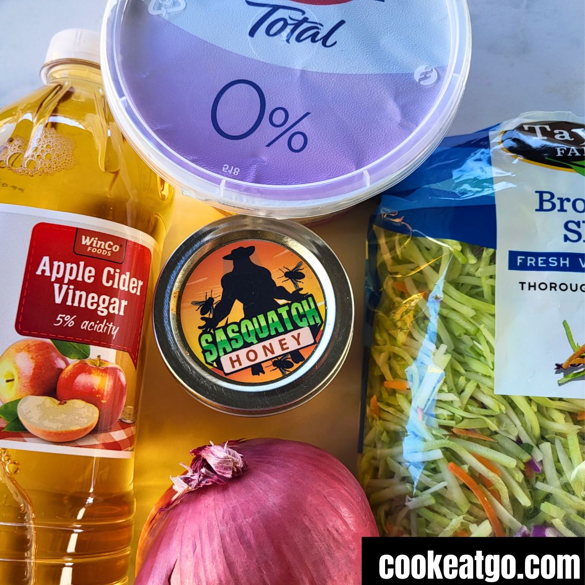 Fat Free Greek yogurt, apple cider vinegar, honey, broccoli slaw, and red onion laid out