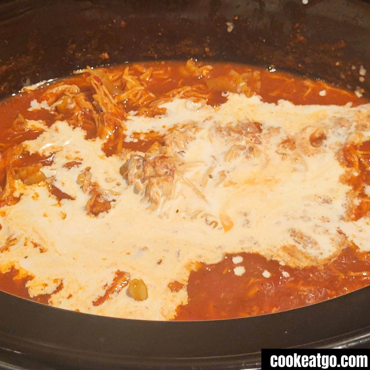 Heavy cream poured into slow cooker chicken parm soup