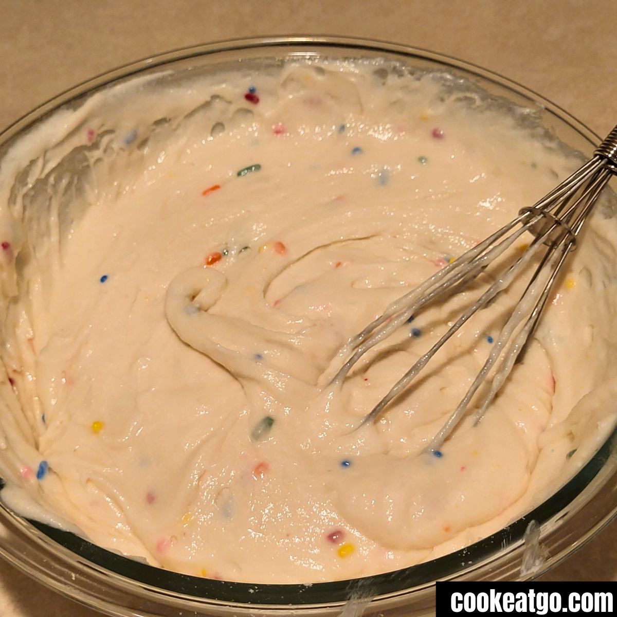 3 Ingredient Cake mix funfetti muffin batter in pyrex bowl with whisk