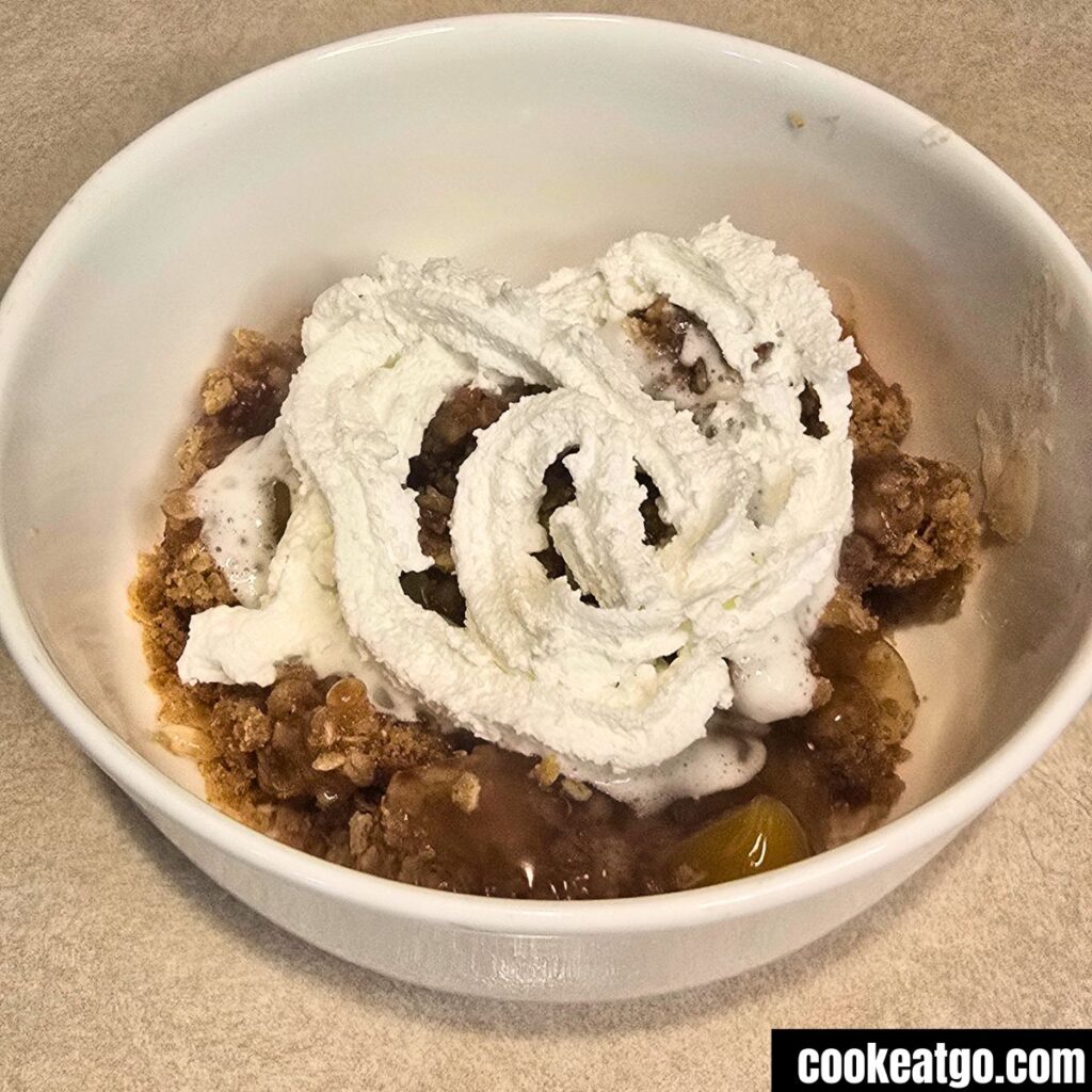Peach Crisp in White Bowl With Whipped Topping
