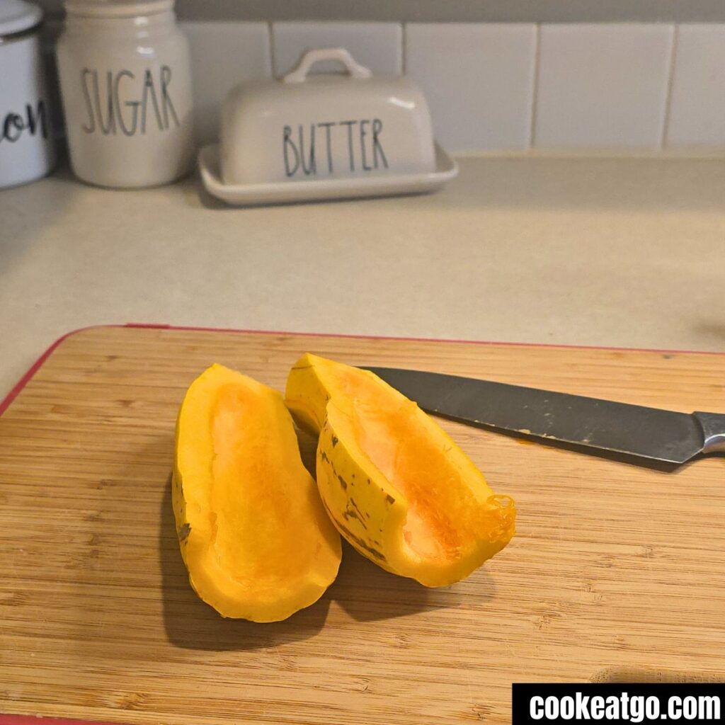 Delicata Squash halved and deseeded on a cutting board