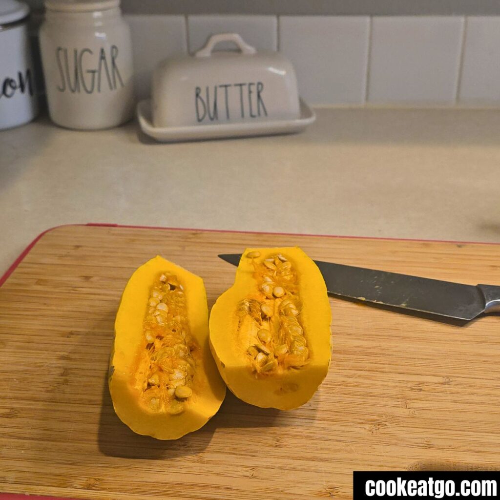 Delicata Squash sliced in half on cutting board