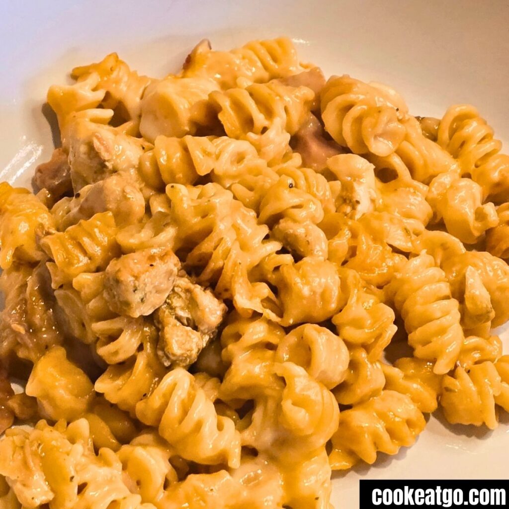 Cooked Bacon and Chicken pasta on a white plate