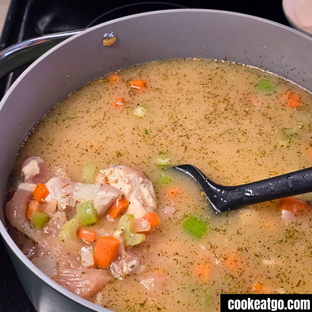 High Protein Chicken Noodle Soup Cooking in caraway Dutch Oven