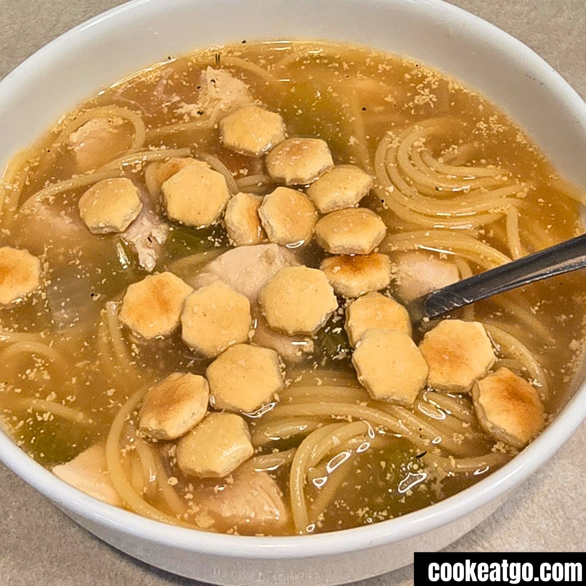 High Protein Chicken Noodle Soup Served With Oyster Crackers in a white bowl